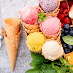 Various of ice cream flavor in cones with berries in wooden box setup on concrete background . Summer and Sweet menu concept.